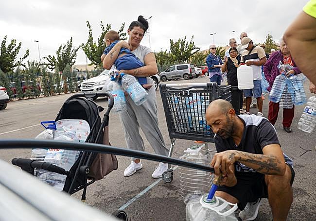 Raúl carga agua en San Pedro, junto a su mujer y su hijo.