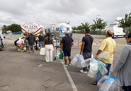 Vecinos de San Pedro del Pinatar, con botellas ante un camión cisterna.