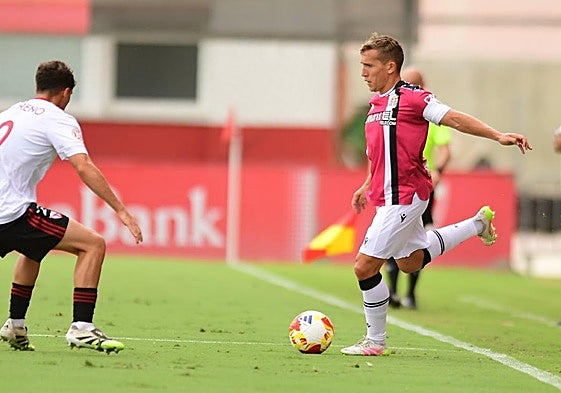 Pablo de Blasis, con el balón en los pies, intenta dar un pase ante la presión de Jorge Moreno, lateral derecho del Sevilla Atlético.