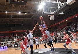 Jonah Radebaugh intenta una entrada a canasta con tráfico en la zona, mientas sus compañeros Moussa Diagne y Will Falk ya se posicionan para el posible rebote ofensivo.