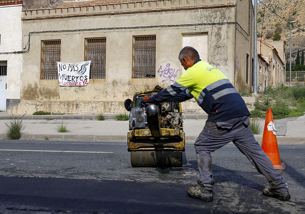 Un operario remata el asfaltado de uno de los baches de la zona.