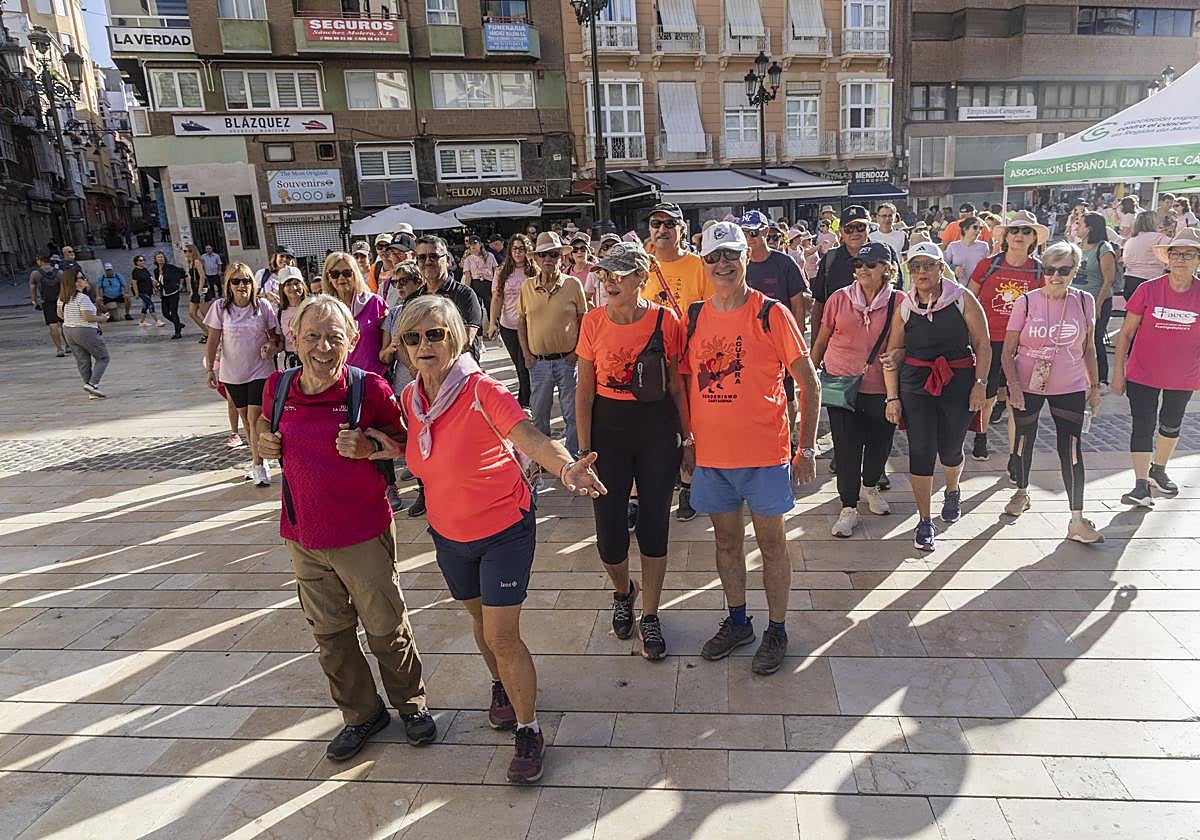 Los participantes en la marcha senderista por el cáncer de mama parten del stand.