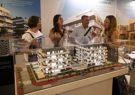 Una joven acompañada de sus padres recibe información sobre una promoción de viviendas en Murcia, ayer.