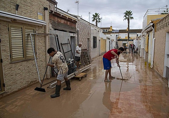 Vecinos de Los Alcázares limpian con escobas y mangueras el barro de sus calles tras la dana.