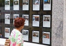 Una persona mirando los anuncios de una inmobiliaria, en una foto de archivo.