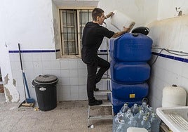 Imanol Oliver echando agua en un depósito.