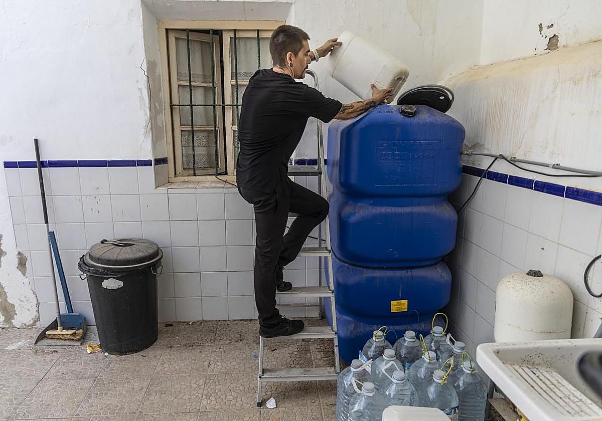 Imanol Oliver echando agua en un depósito.