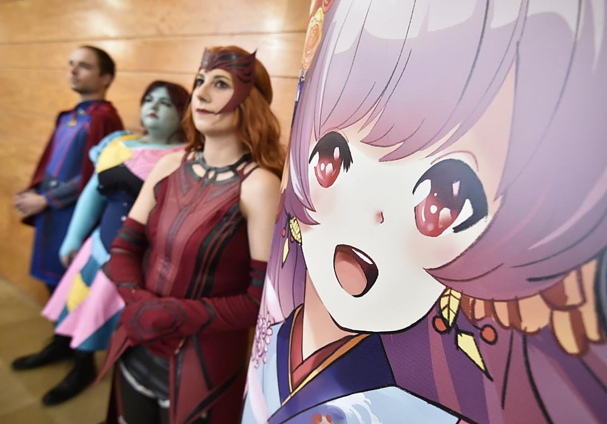 Tres 'cosplayers' junto al cartel de 'Murcia se Remanga', en la presentación del salón, este martes.