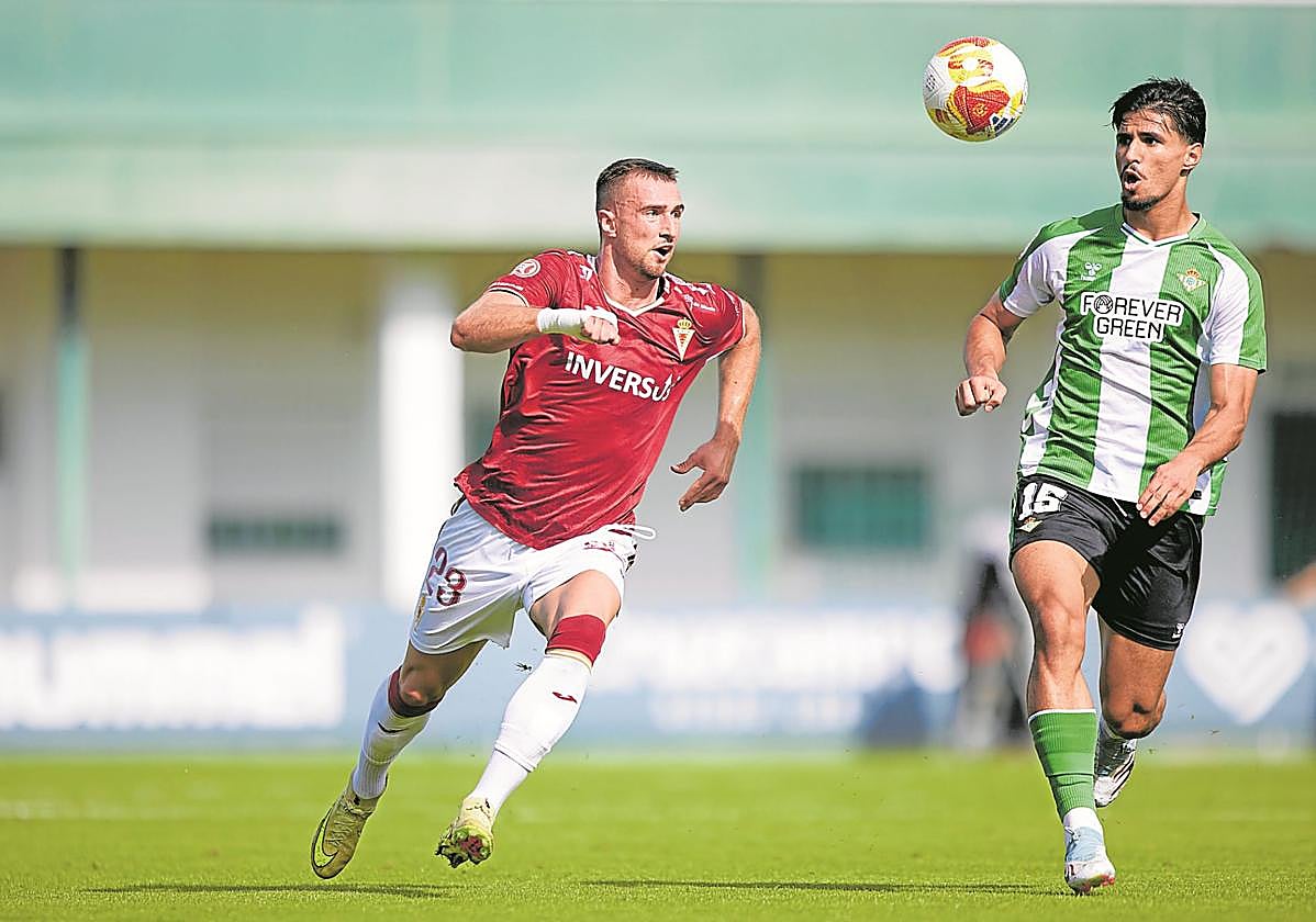 David Flakus, delantero del Real Murcia, persigue un balón ante Moha, defensa del Betis Deportivo, en el partido del pasado fin de semana.