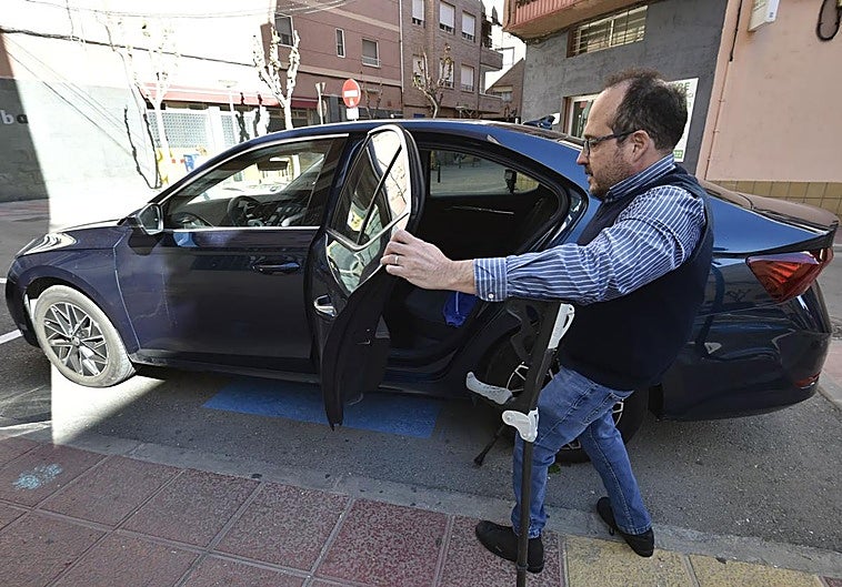 «Hay días que desisto de ir al centro»: Juanjo Segado sube a su coche, en una plaza para personas con movilidad reducida.
