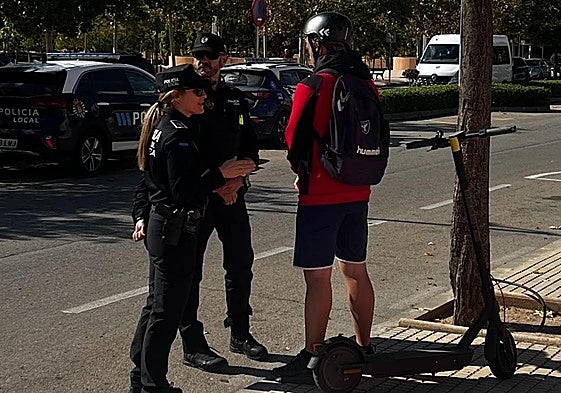 Dos agentes explican los detalles de la normativa a un vecino.
