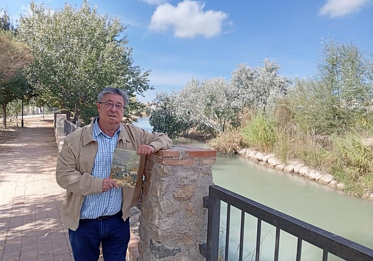 Francisco Salmerón, con su libro en la mano, en un paseo junto al río Segura en Cieza.