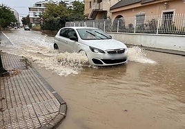 Un vehículo atraviesa una carretera anegada de lluvia en Murcia en una imagen de archivo.