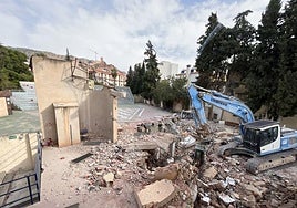 La máquina derribando una parte del escenario este jueves.