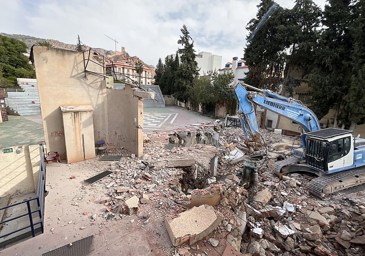 La máquina derribando una parte del escenario este jueves.