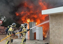 Los bomberos mientras sofocan las llamas.