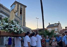 Un vecino pasea con su bici frente a la iglesia de Los Urrutias, este miércoles.