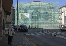 Un vecino camina con una bolsa de la compra frente a la antigua fundición Frigard.