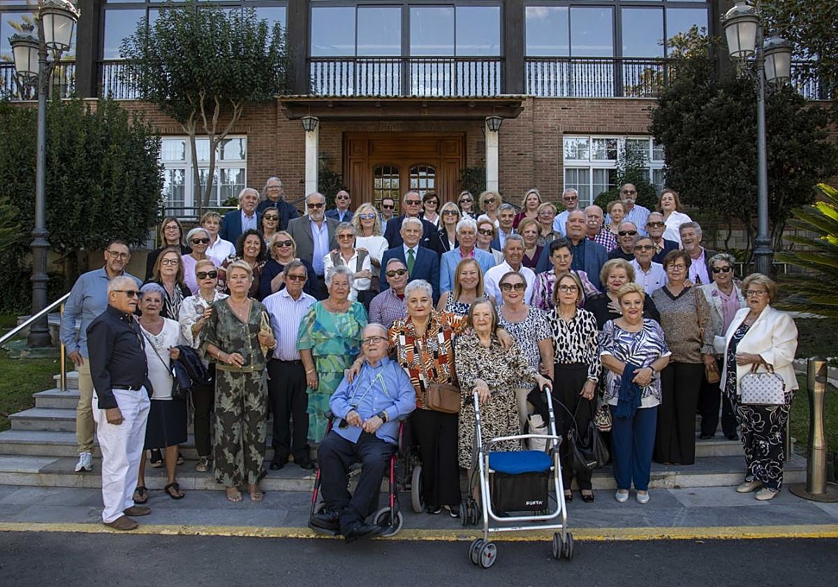 Los sesenta vecinos posan en la escalera de entrada al Club Naval de Oficiales, junto a Joaquín García Pérez (sentado en el centro), durante la jornada de encuentro de residentes de la calle Monroy.