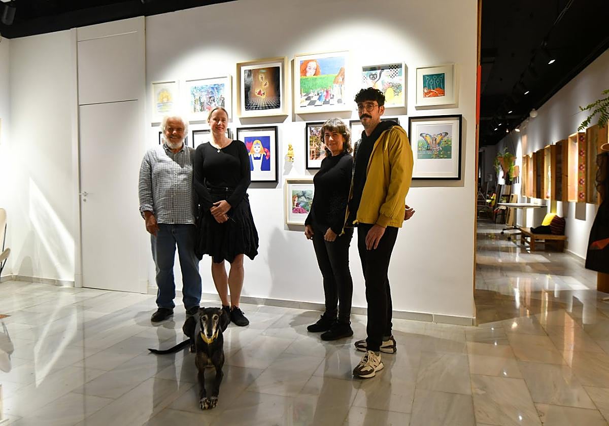 El montaje y las obras. Ramón Garrigues, Katarzyna Rogowicz, Virtudes Fenor y Fuli García, con la galga 'Mamba', ante las obras de 'Marina en el País de las Maravillas' en Studio K.
