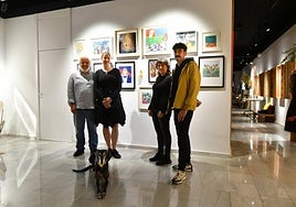 El montaje y las obras. Ramón Garrigues, Katarzyna Rogowicz, Virtudes Fenor y Fuli García, con la galga 'Mamba', ante las obras de 'Marina en el País de las Maravillas' en Studio K.