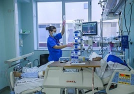 Una enfermera trata a un paciente en la UCI de La Arrixaca.