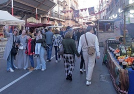 Numerosas personas pasean entre los puestos del Mercado Medieval en la calle del Duque.