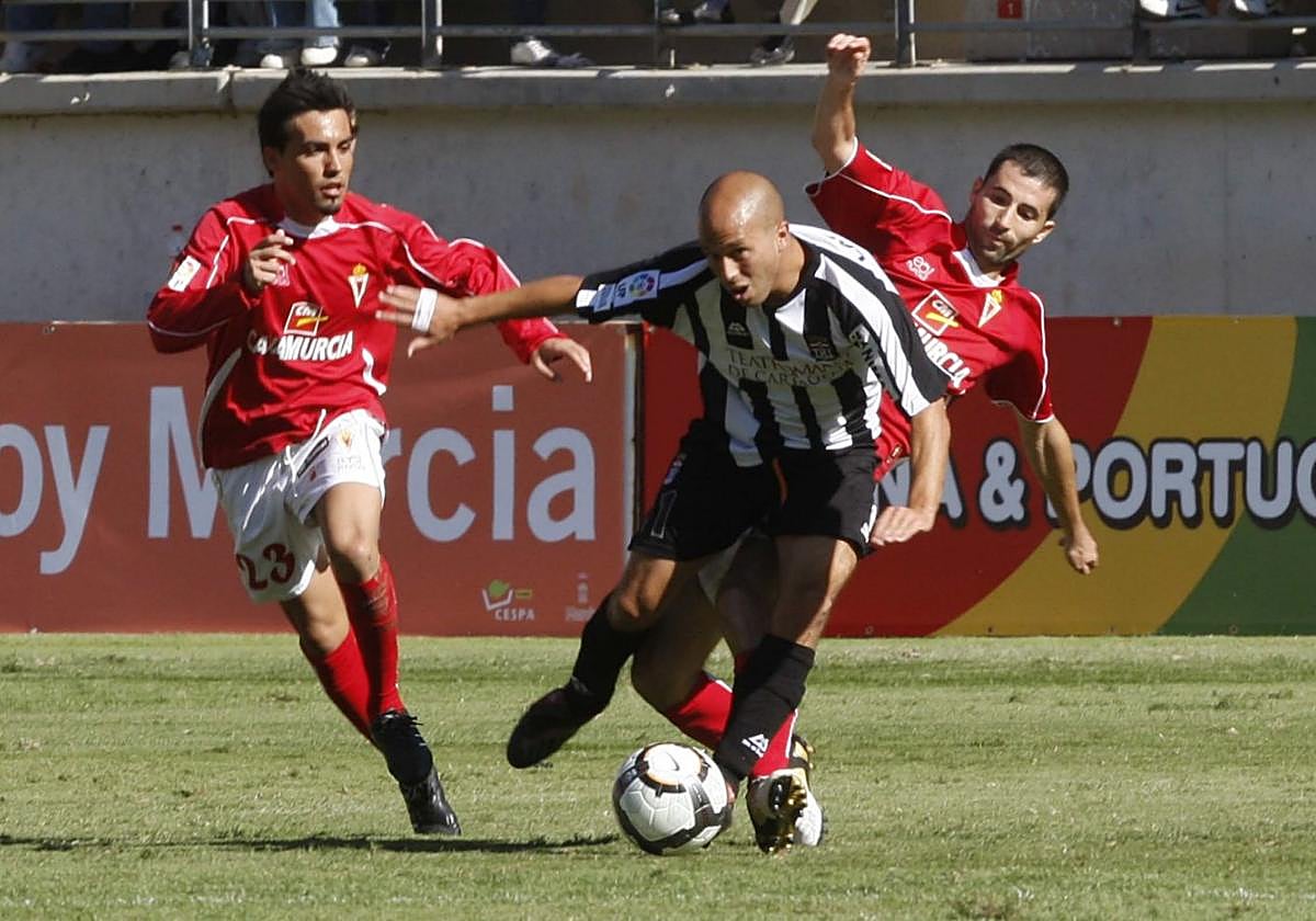 08/11/2009. Ander Lafuente deja atrás a Albiol y Pedro en un partido en el que el Efesé pasó por encima de su eterno rival con 8.000 cartageneros llenando un fondo del coliseo grana.