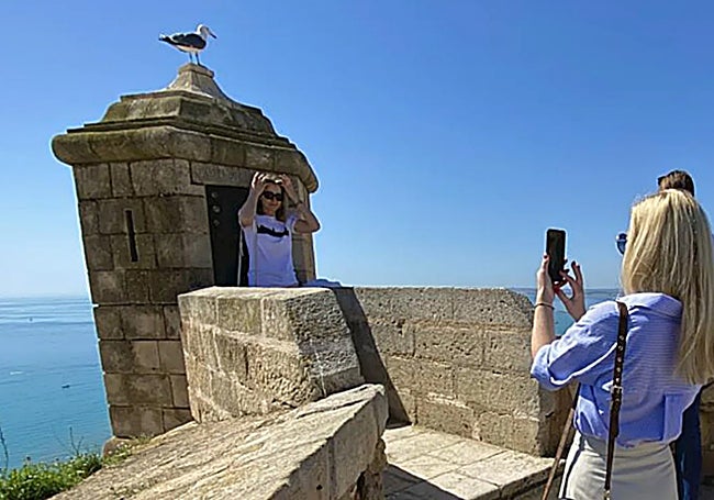 Dos turistas se fotografían en el Castillo de Santa Bárbara.