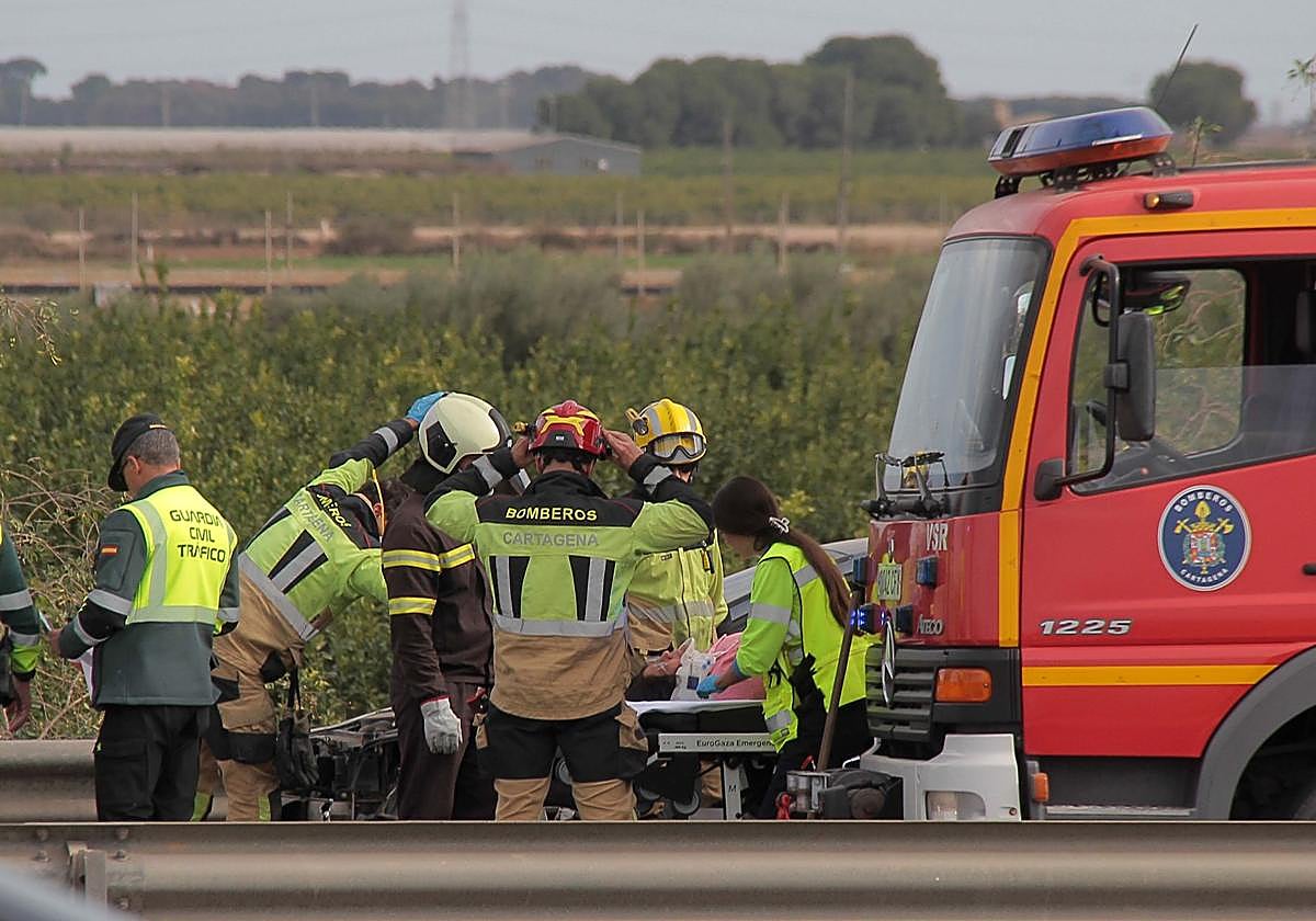 Efectivos de bomberos y Guardia Civil junto a los sanitarios que han atendido a la mujer que ha resultado herida en el accidente de El Albujón.