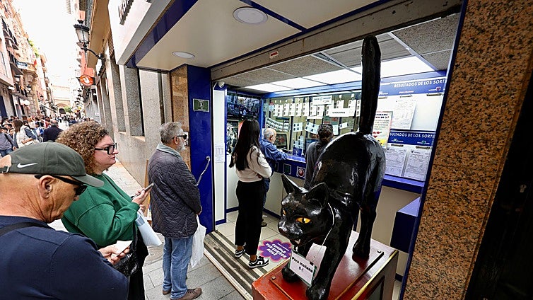 Cola para comprar Lotería de Navidad en la administración El Gato Negro, en Murcia.