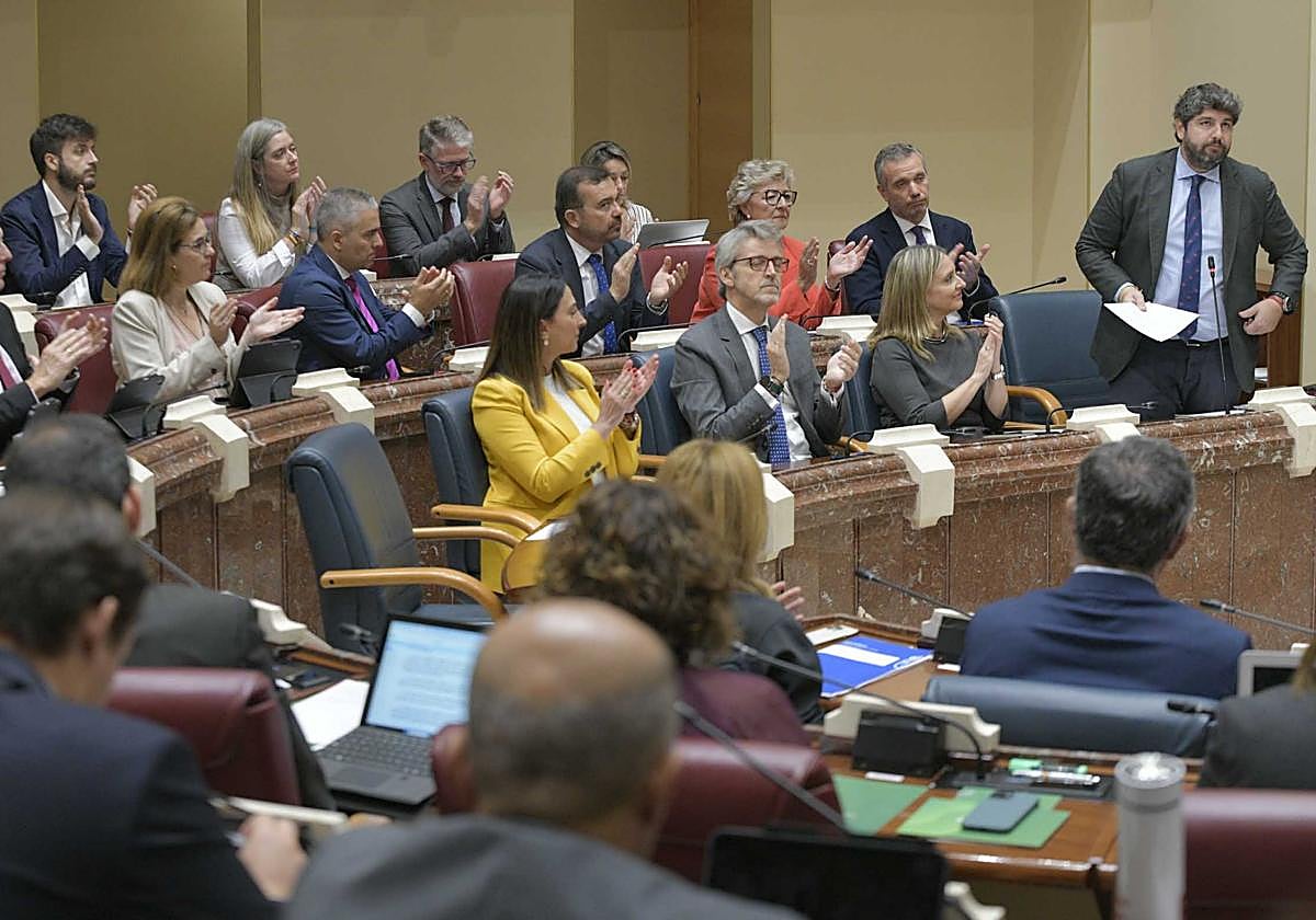 Diputados del PP y consejeros aplauden al presidente de la Comunidad, Fernando López Miras, durante un Pleno de la Asamblea.