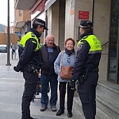 Los agentes conversan en la calle Mayor con una vecina del barrio de San Cristóbal que lleva el bolso colgado al cuello para evitar que se lo roben.