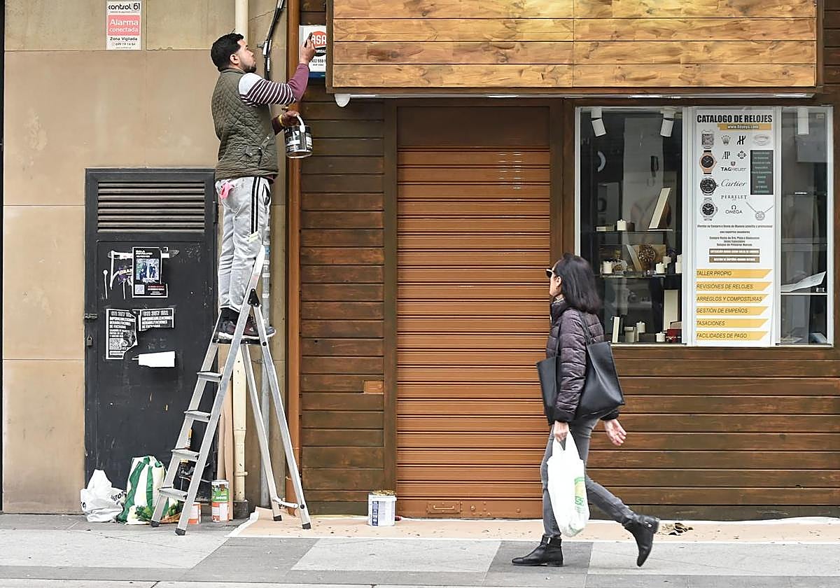 Un inmigrante repara una fachada en una imagen de archivo..
