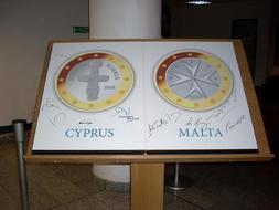 Panel en el que se muestra la cara de las nuevas monedas europeas en Chipre y en Malta./ EFE