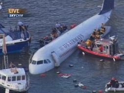 Las fuerzas de seguridad intentan rescatar a los tripulantes del avión que flota en el río Hudson. / Ap