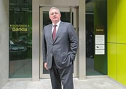 Francisco Verdú posa delante de una sucursal de Bankia. / Efe
