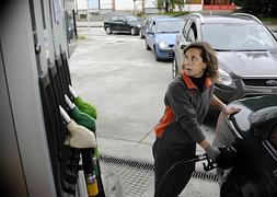 Una empleada de una gasolinera llena el depósito de un vehículo. / Ignacio Pérez