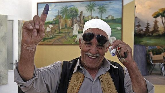 Un libio muestra su dedo de tinta tras ejercer su derecho al voto. 