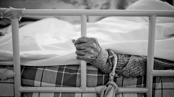 Un anciano atado a una cama en en un geriátrico. 
