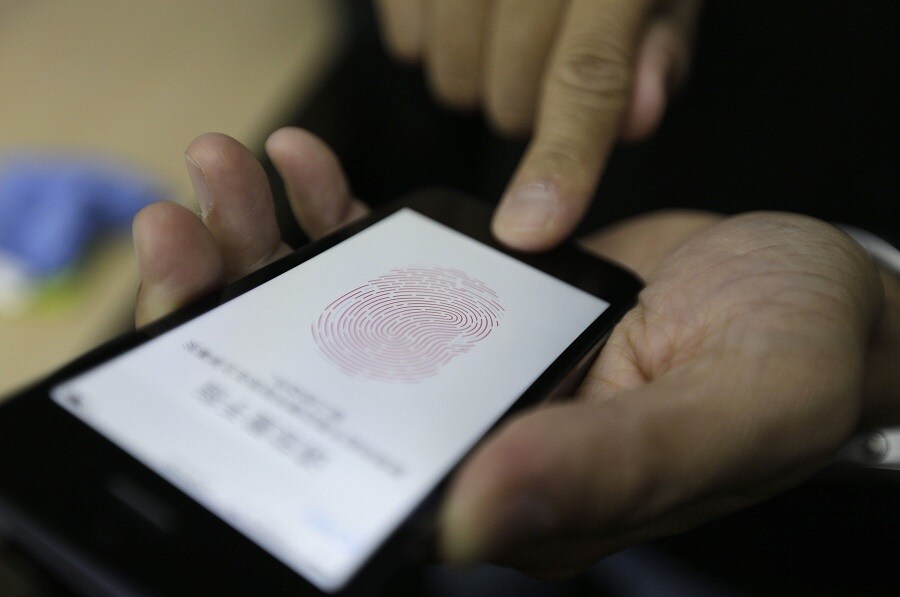 Una persona prueba el desbloqueo dactilar del iPhone5. 