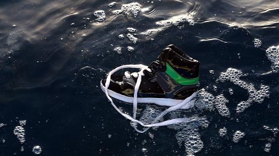 Un zapato perteneciente a uno de los inmigrantes ahogados en el mar, flota en el agua 