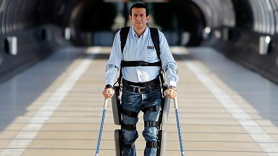Un hombre camina con ayuda de un exoesqueleto. 