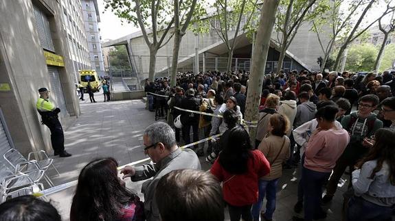 Curiosos, profesores y estudiantes, en torno al cordón policial establecido en el instituto.