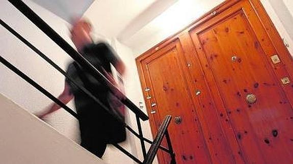 Un joven sube las escaleras frente a la vivienda en la que apareció el cuerpo sin vida del niño. 