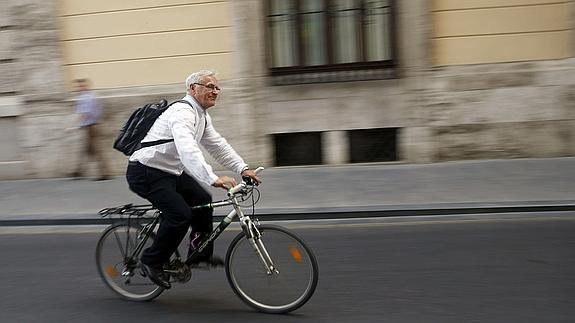 El nuevo alcalde de Valencia, Joan Ribó, sale con su bicicleta del Ayuntamiento en su primer día laborable en el cargo.