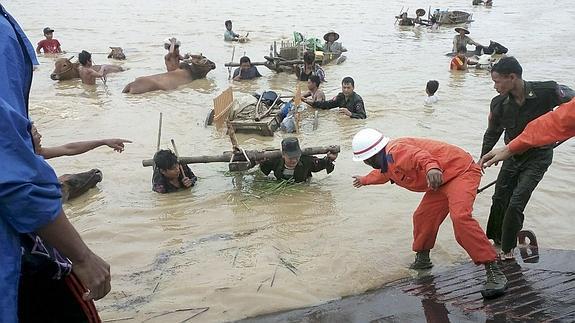 Los equipos de rescate tratan de auxiliar a varias personas afectadas por las inundaciones en Birmania.