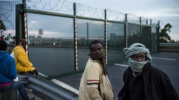 Inmigrantes esperan a intentar cruzar a Inglaterra en el puerto de Calais.