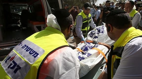 Voluntarios israelíes trasladan a una de las víctimas del ataque perpetrado contra un autobús. 