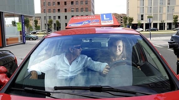 Profesor de autoescuela dando una clase practica a una joven, en Vitoria.